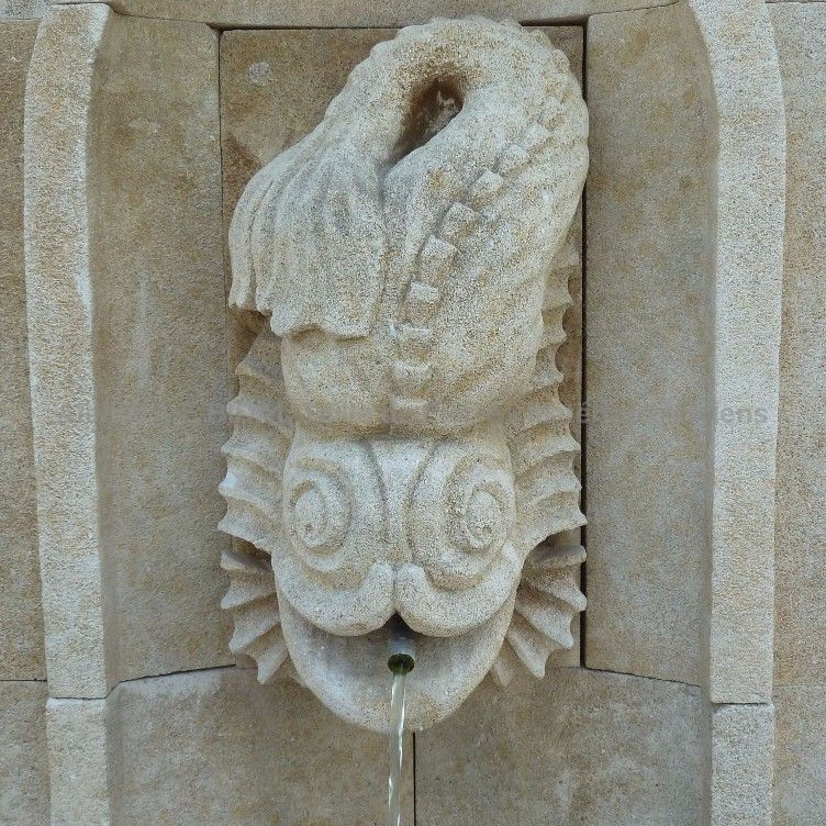 Sculpture en pierre réalisée par notre artisan sculpteur tailleur de pierre sur une fontaine murale d'extérieur.