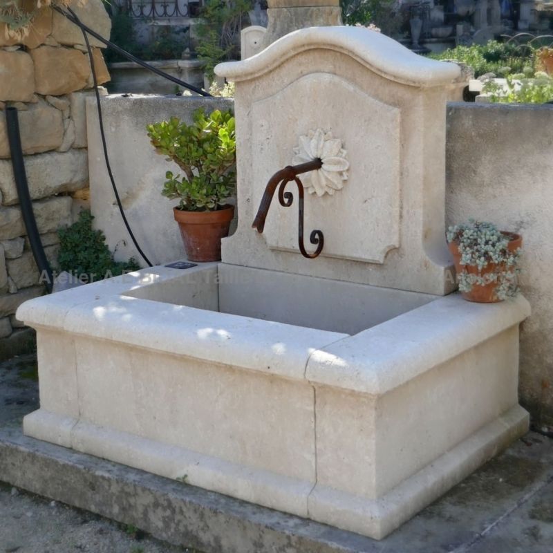 Small wall fountain in stone ǀ A rustic fountain crafted by our stone-mason Alain BIDAL in Provence