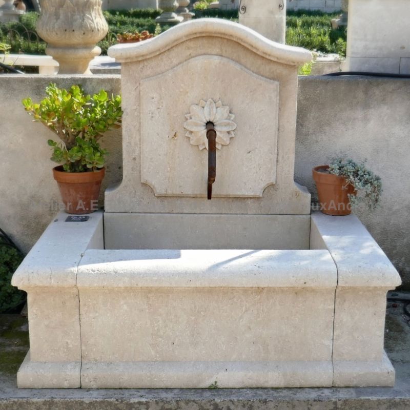 Small wall fountain in natural stone crafted by the stone mason Alain Bidal (Provence)